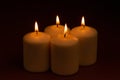 Four whiteÃÂ candlesÃÂ flameÃÂ burningÃÂ onÃÂ dark backgroundÃÂ withÃÂ copyÃÂ space forÃÂ text Royalty Free Stock Photo